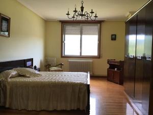 um quarto com uma cama, uma janela e uma cadeira em Casa Tino 2 em Montederramo