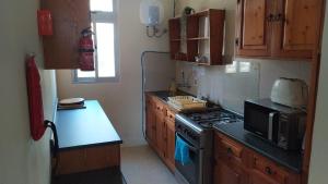 eine Küche mit einem Herd und einer Mikrowelle in der Unterkunft Sea View 2 bedroom apartment in Marsaskala