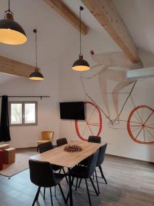 a dining room with a table with chairs and a bike on the wall at Le Lodge du Parc in Beaune