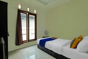 a bedroom with a bed and a window at OYO Life 92258 Kostel 21 Syariah in Semarang