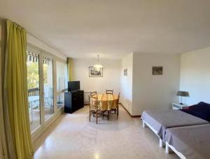 a living room with a bed and a dining room table at Studio Les Bastides in Gréoux-les-Bains