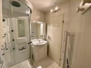 a white bathroom with a sink and a shower at Studio Les Bastides in Gréoux-les-Bains