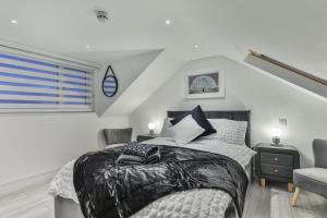 a bedroom with a bed and a chair at The Hepburn - Top Floor - Luxury for up to 6 guests near Open Air Theatre and North Bay in Scarborough