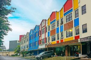een kleurrijk gebouw met een auto voor de deur bij SUPER OYO 92271 Orienchi 3 in Tangerang