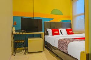 a bedroom with two beds and a flat screen tv at SUPER OYO 92271 Orienchi 3 in Tangerang