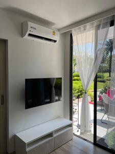 sala de estar con TV de pantalla plana en la pared en SkyPark Laguna Phuket, en Bang Tao Beach