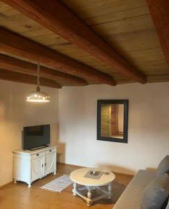 ein Wohnzimmer mit einem Sofa, einem TV und einem Tisch in der Unterkunft ADORI in Ilirska Bistrica