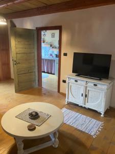 a living room with a table and a flat screen tv at ADORI in Ilirska Bistrica