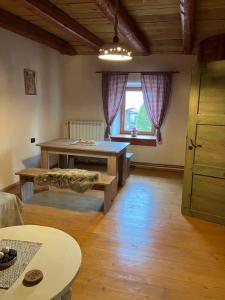 ein Wohnzimmer mit einem Tisch und einem Fenster in der Unterkunft ADORI in Ilirska Bistrica
