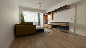 a living room with a yellow chair and a television at Luxury Apart Dorobanți in Bucharest