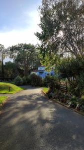 a road in front of a blue house at Appart Cosy Green, Océan, Golf, Piscine, Wifi in Moliets-et-Maa