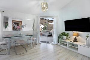 uma sala de estar com uma mesa e uma televisão em Bahía del Amanecer em Santa Cruz de Tenerife