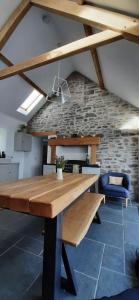 uma mesa de madeira num quarto com uma parede de pedra em Pass the Keys Character country cottage with scenic castle views em Llandeilo
