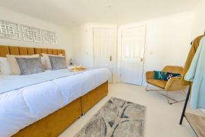 a bedroom with a large bed and a chair at Modern 4-Level Townhouse for 8 Free Parking Bournemouth in Bournemouth