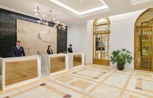 a lobby with three people standing in a room at InterContinental Athenee Palace Bucharest, an IHG Hotel in Bucharest