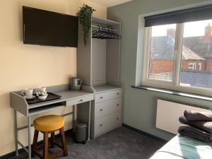 a bedroom with a desk and a bed and a window at The Bridge Inn in Tenbury +13 photos