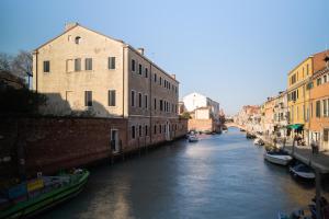 een kanaal in een stad met gebouwen en boten bij Rimon Place-Kosher in Venetië
