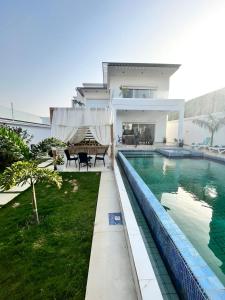 una casa con piscina di fronte a una casa di Diamond House a Saly Portudal