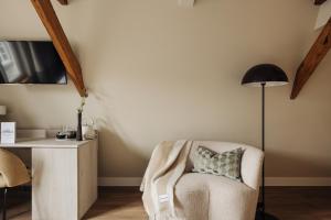 Zimmer mit einem Stuhl und einem Schreibtisch mit einer Lampe in der Unterkunft Adam Suites Hotel in Amsterdam