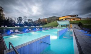 una gran piscina con sillas y un edificio en Las Caldas by blau hotels en Las Caldas