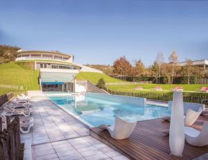a swimming pool with chairs and a building at Las Caldas by blau hotels in Las Caldas