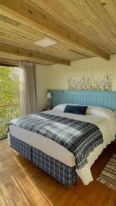 uma cama num quarto com tecto em madeira em Cabana Mirim Estalagem Rural em Gramado