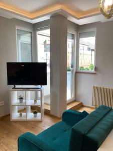a living room with a blue couch and a flat screen tv at Garay Center Relax in Budapest