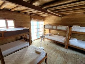 a room with four bunk beds in a cabin at Hostel villa luz Beach in Tintipan Island
