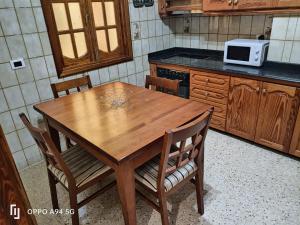 cocina con mesa de madera con sillas y microondas en Casa Guanche II, en Cruce de Arinaga