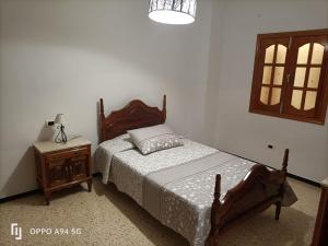 een slaapkamer met een bed en een tafel met een lamp bij Casa Guanche II in Cruce de Arinaga