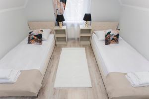 three beds in a room with white walls at Willa Marcella in Białystok