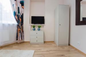 a living room with a tv and a white cabinet at Willa Marcella in Białystok