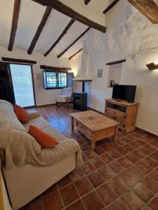 een woonkamer met een bank en een tv bij Cuevas Cañada Honda in Margen de Arriba