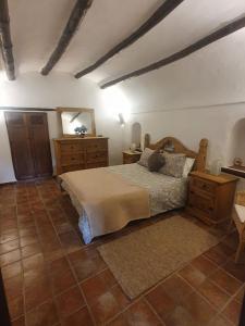 1 dormitorio con cama, muebles de madera y espejo en Cuevas Cañada Honda, 