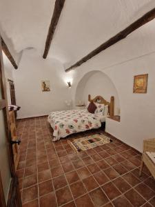 a bedroom with a bed and a tiled floor at Cuevas Cañada Honda 