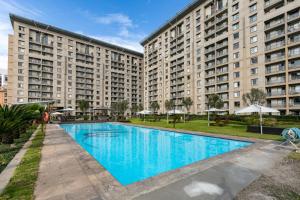 a large apartment building with a large swimming pool at RAD STAYS - 60 Westpoint 89 Grayston Dr Morningside in Johannesburg