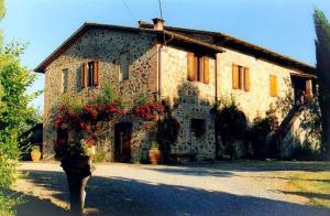 uma velha casa de pedra com flores em frente em Poggio Vitignano Charming Cottage With Pool and Parking em Pianella