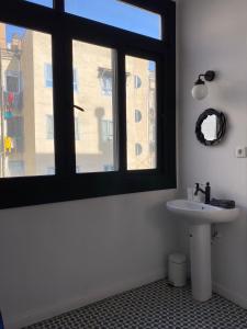 ein Badezimmer mit einem Waschbecken und einem großen Fenster in der Unterkunft Spacious Modern Apartment in the Vibrant El Raval in Barcelona