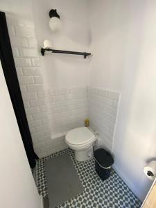 a small bathroom with a toilet and a tile floor at Spacious Modern Apartment in the Vibrant El Raval in Barcelona