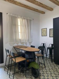 a table and chairs with a scooter in a room at Spacious Modern Apartment in the Vibrant El Raval in Barcelona