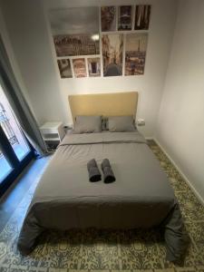 ein Schlafzimmer mit einem Bett und Hausschuhen darauf in der Unterkunft Spacious Modern Apartment in the Vibrant El Raval in Barcelona