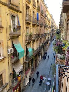 eine Gruppe von Menschen, die eine Straße mit Gebäuden entlang gehen in der Unterkunft Spacious Modern Apartment in the Vibrant El Raval in Barcelona