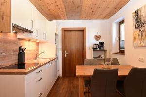 cocina con mesa de madera y techo de madera en Zugspitze, en Biberwier