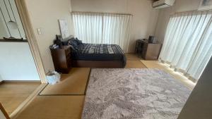 1 dormitorio con cama y alfombra en ELM On The Beach en Kitaibaraki