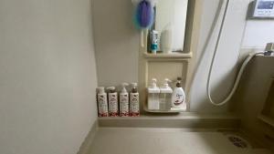 a bathroom with four shampoo bottles sitting on a shelf at ELM On The Beach in Kitaibaraki