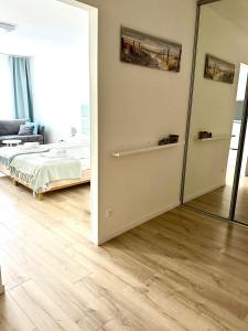 ein Schlafzimmer mit einem Spiegel und einem Bett in einem Zimmer in der Unterkunft AL-DOM apartamenty Grey 112 Olymp in Kołobrzeg