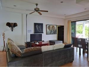 a living room with a couch and a flat screen tv at Ocean View Villa in Koh Tao