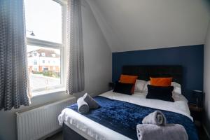 ein Schlafzimmer mit einem Bett und einem Fenster mit Handtüchern darauf in der Unterkunft The Becket - Three Bedroom City Centre House with Parking in Canterbury