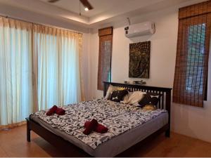 una camera da letto con un letto con cuscini rossi di Ocean View Villa a Ko Tao Altre 37 foto
