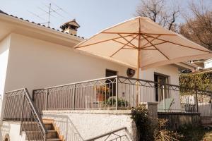 a house with a large umbrella on the front of it at Ca' Dei Cedri in Marciaga in Costermano sul Garda